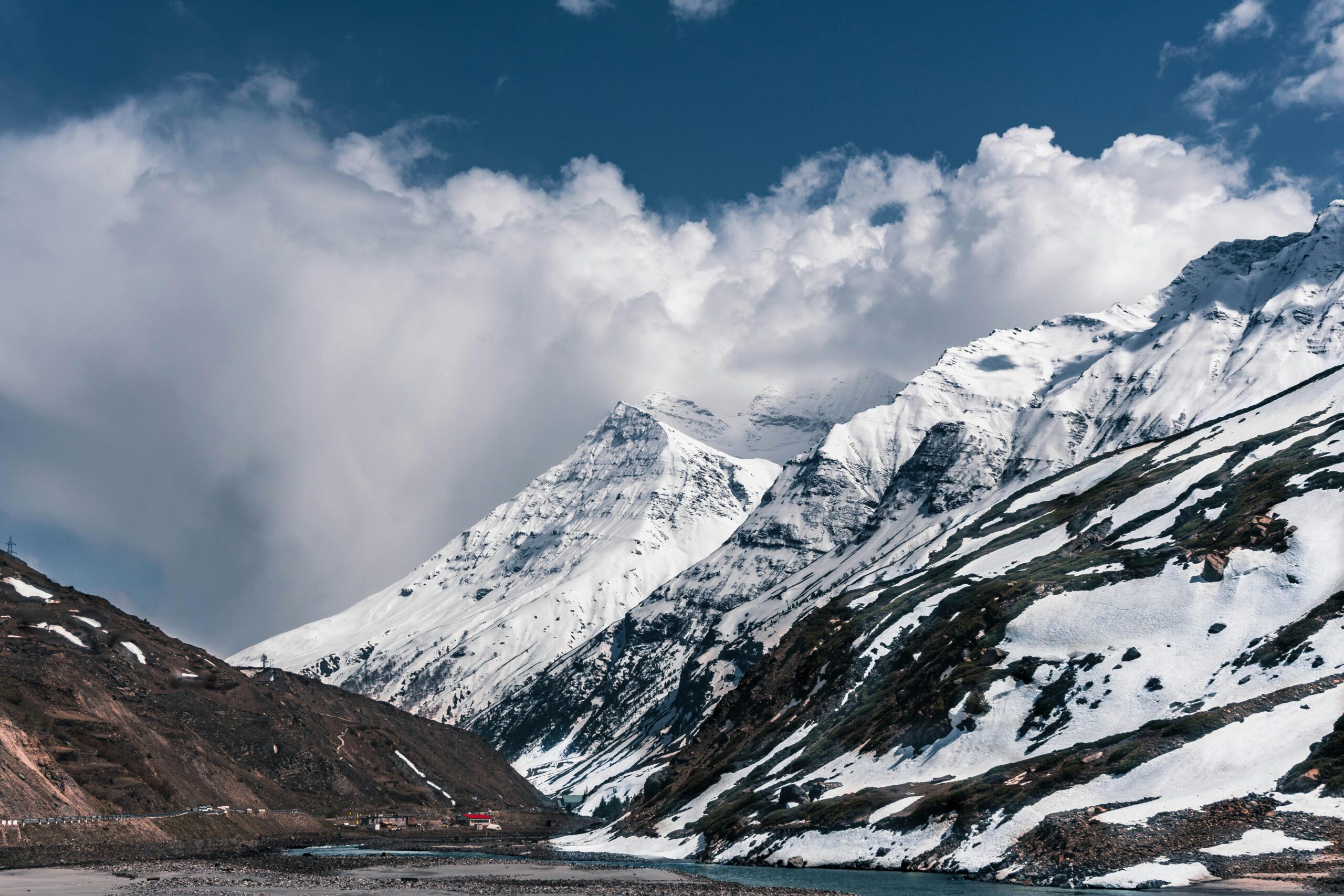 Home Captivating view of the snow-covered mountains in Manali, India, under a dramatic sky.